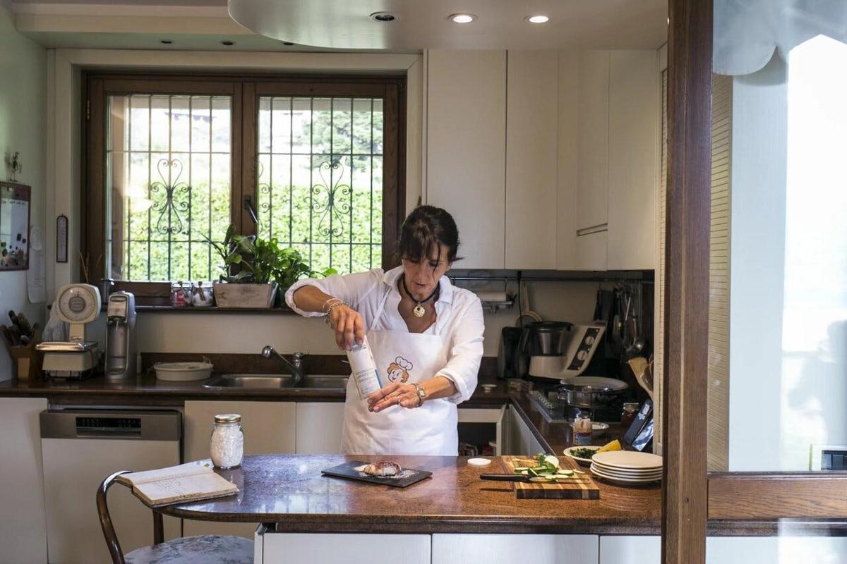 a woman standing in a kitchen preparing food