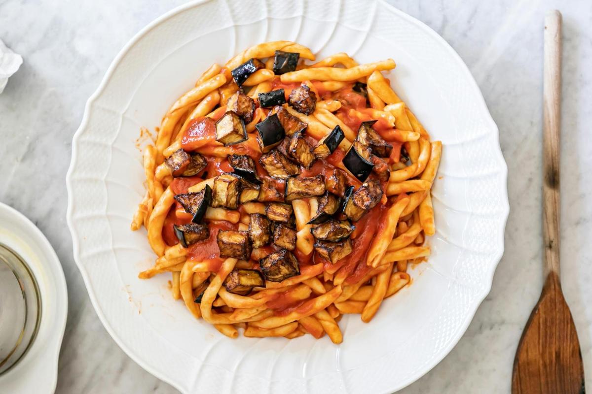 a plate of pasta with mushrooms and tomatoes