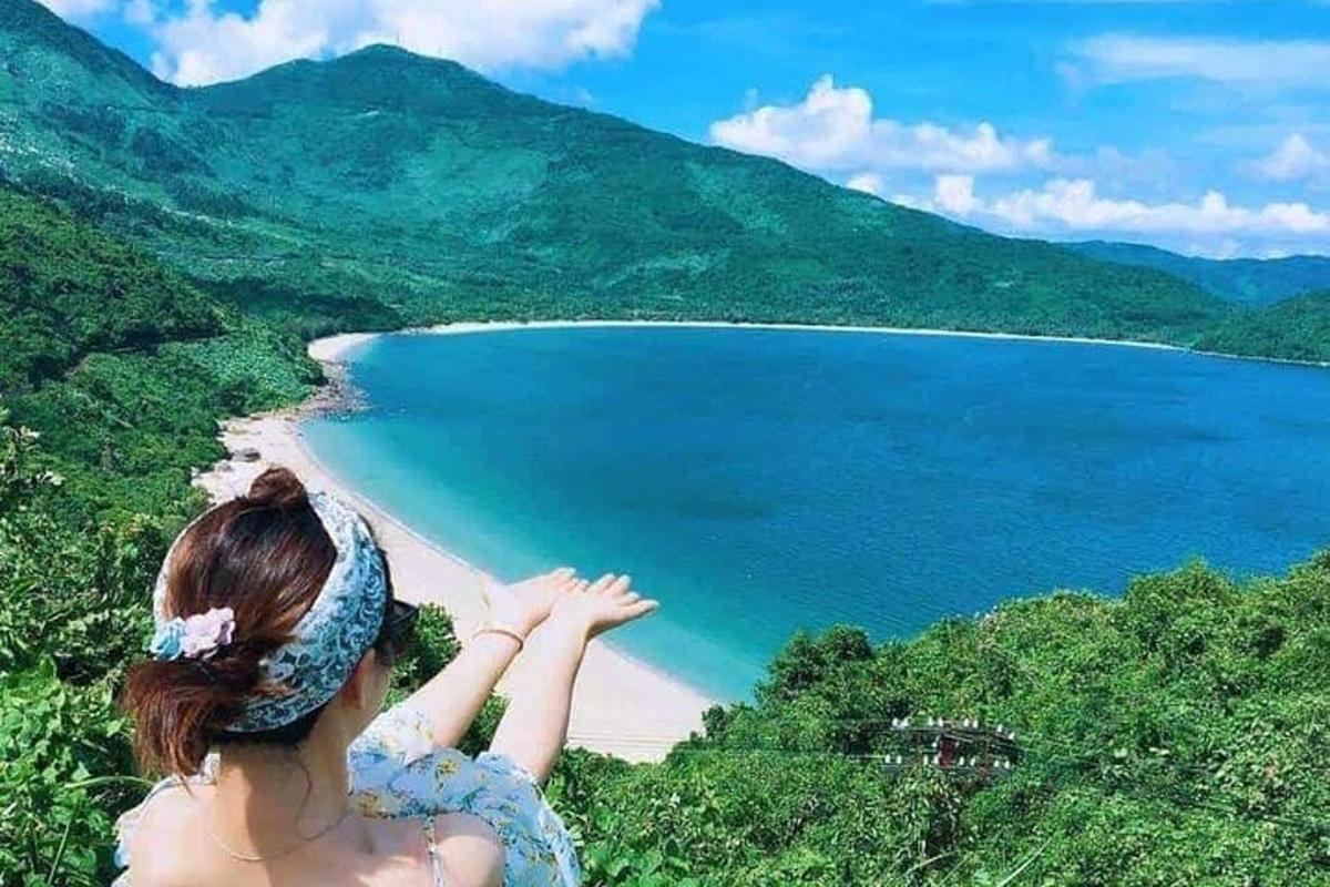 eine Frau, die auf einem Hügel mit Blick auf einen Strand steht