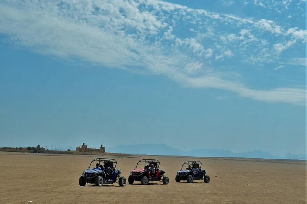 tre veicoli a quattro ruote parcheggiati su una spiaggia sabbiosa