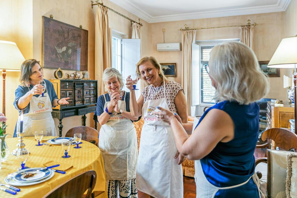 um grupo de mulheres em pé ao redor de uma mesa bebendo vinho