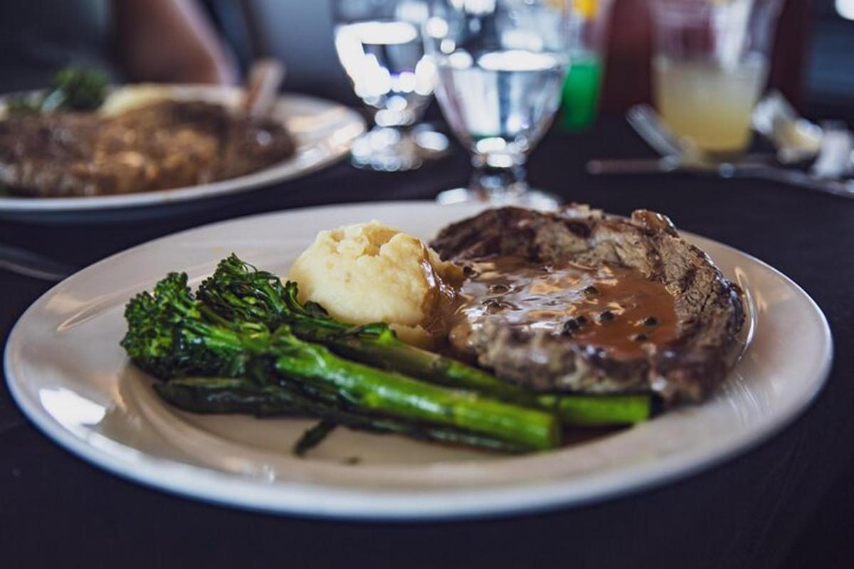 a plate of food with steak and broccoli on a table