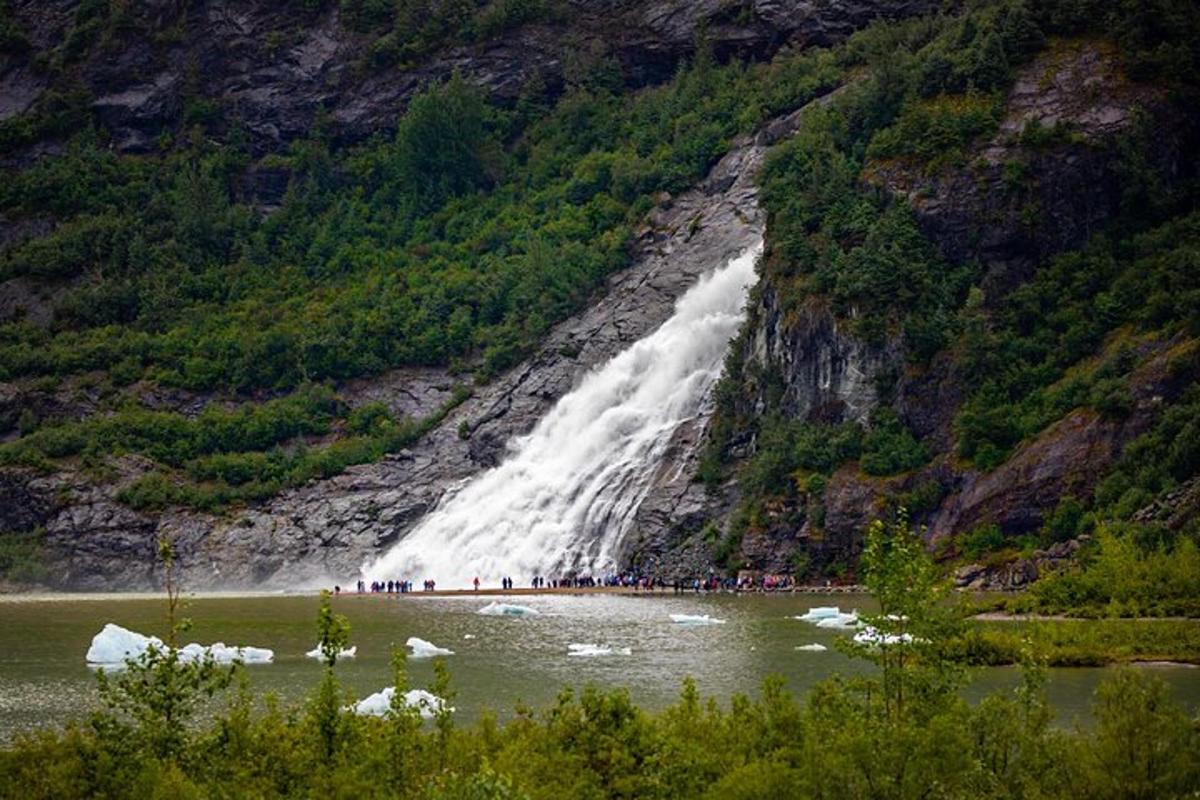 a group of people standing in front of a waterfall