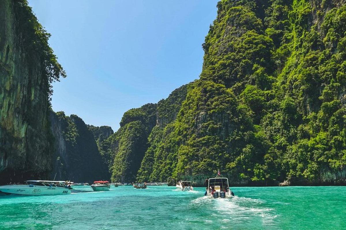 a group of boats in a body of water with cliffs