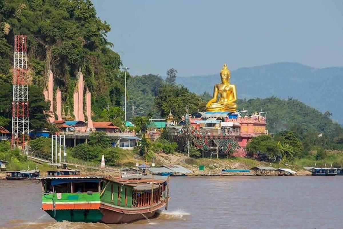 a boat in the water in front of a statue