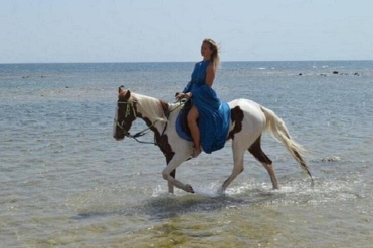 ženska, ki jaha konja na plaži