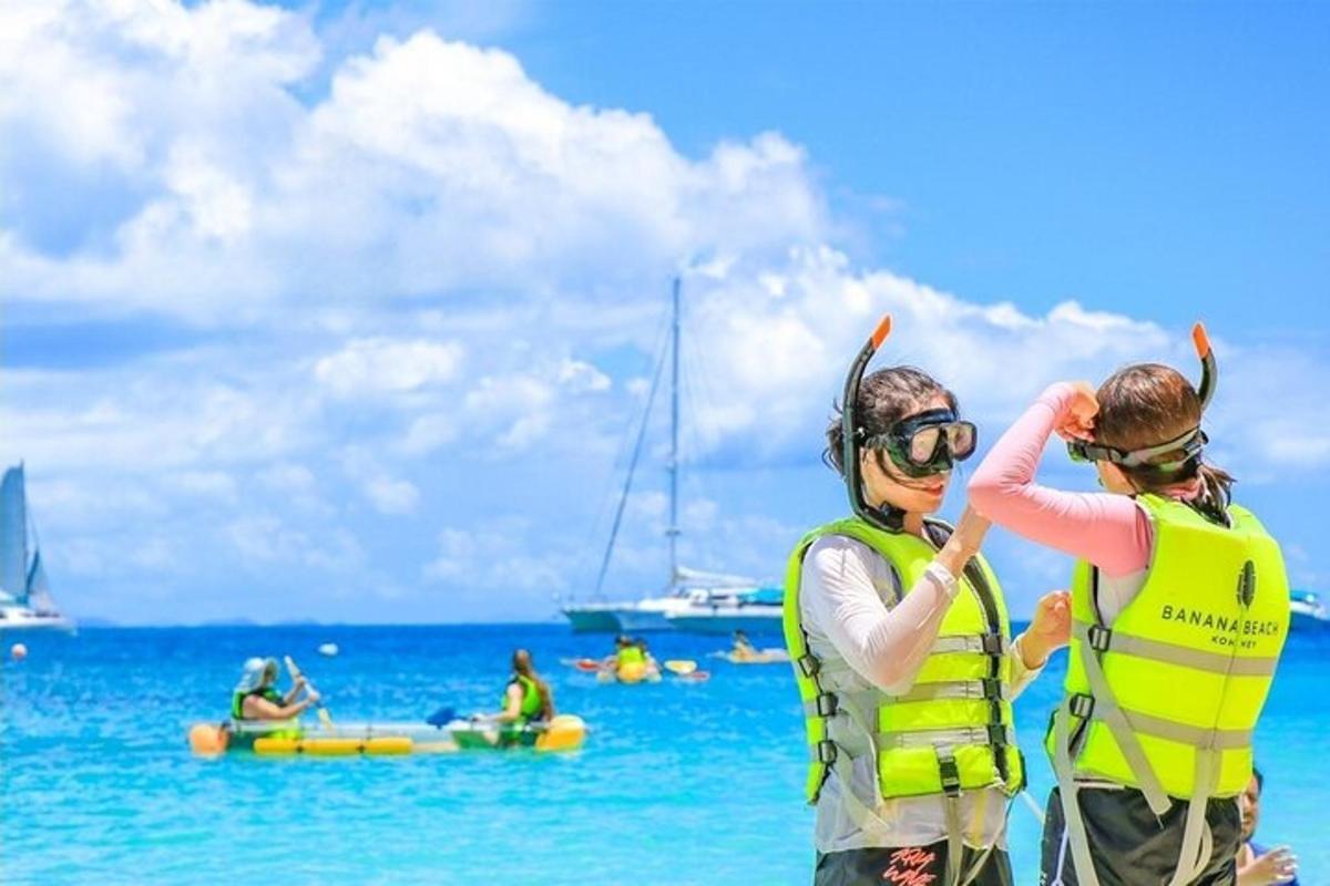 due persone con giubbotti di salvataggio in piedi sulla spiaggia