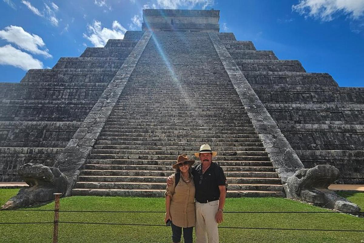 Un hombre y una mujer de pie frente a una pirámide.
