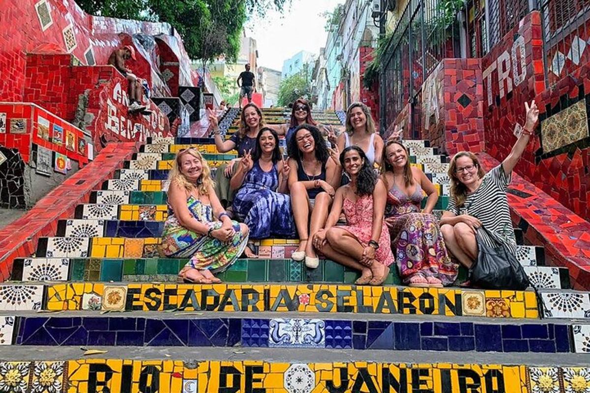 a group of women sitting on the steps of a bus