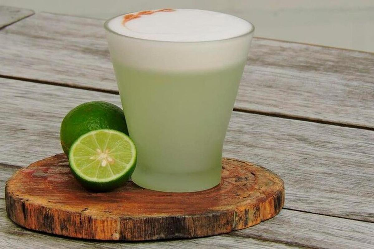 un bicchiere di succo di lime su un tagliere di legno