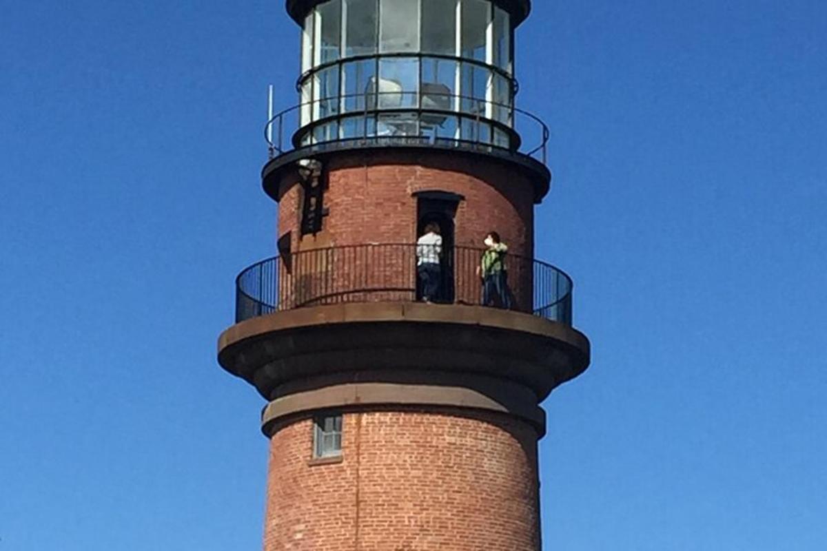 two people standing on top of a lighthouse