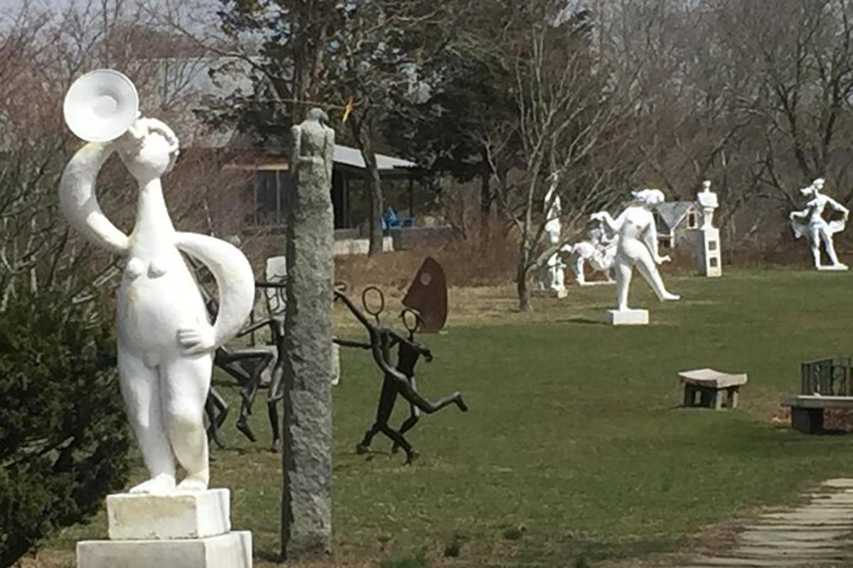 a group of statues of people in a park