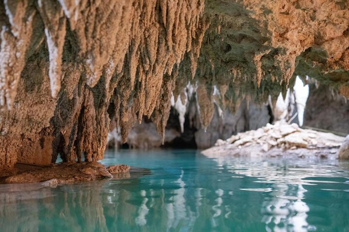 Una cueva con agua azul y carámbanos en su interior.
