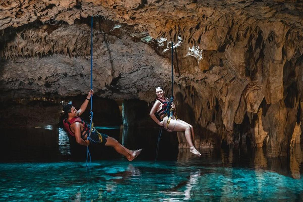 Dos personas con cuerdas en el agua en una cueva.