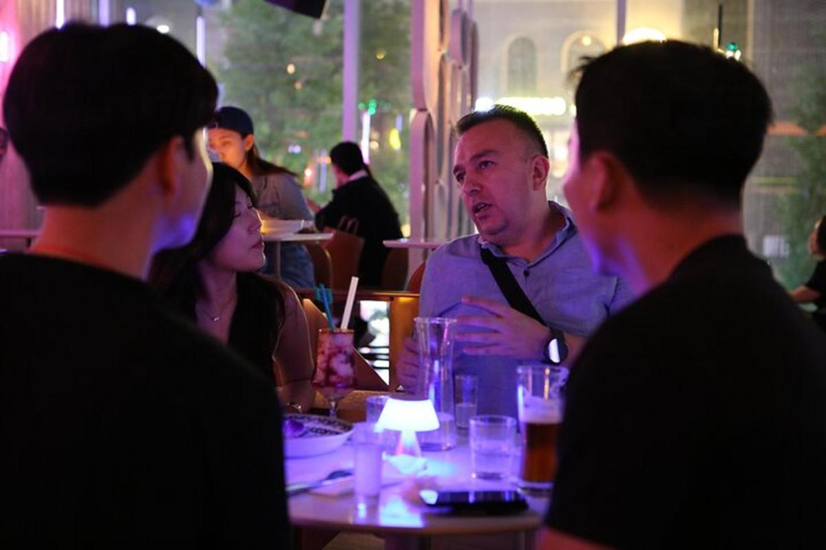 um grupo de pessoas sentadas ao redor de uma mesa em um restaurante