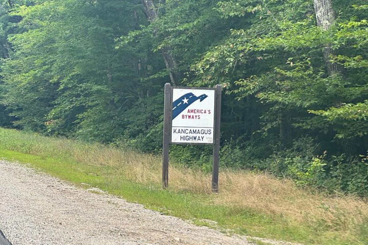a sign on the side of a dirt road