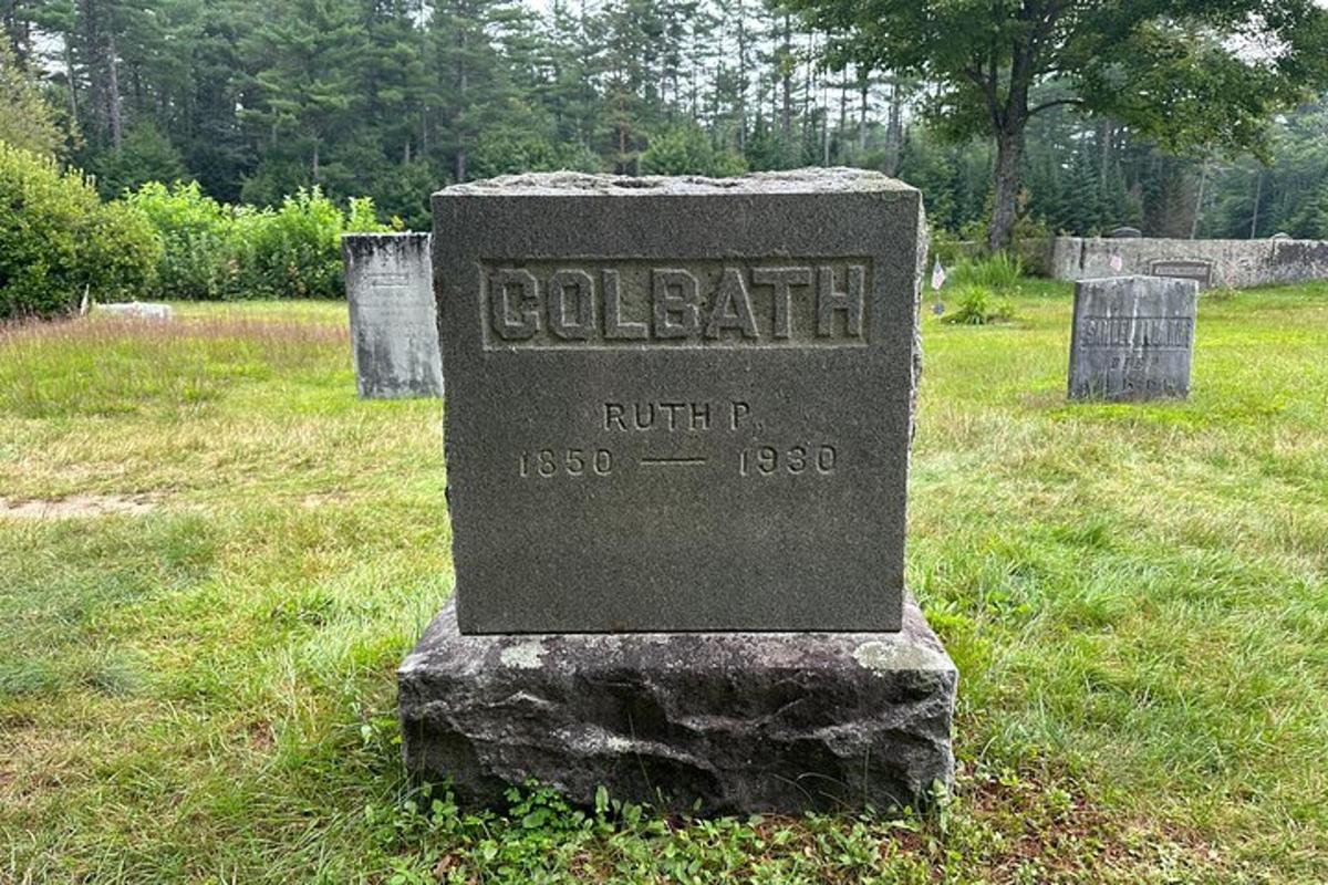 a stone grave sign in a field of grass