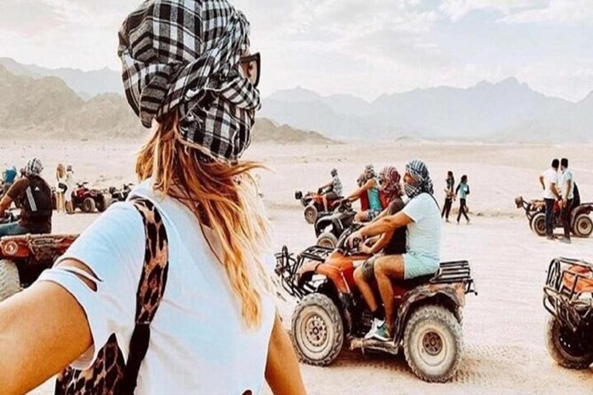 sekumpulan orang menunggang atv di padang pasir