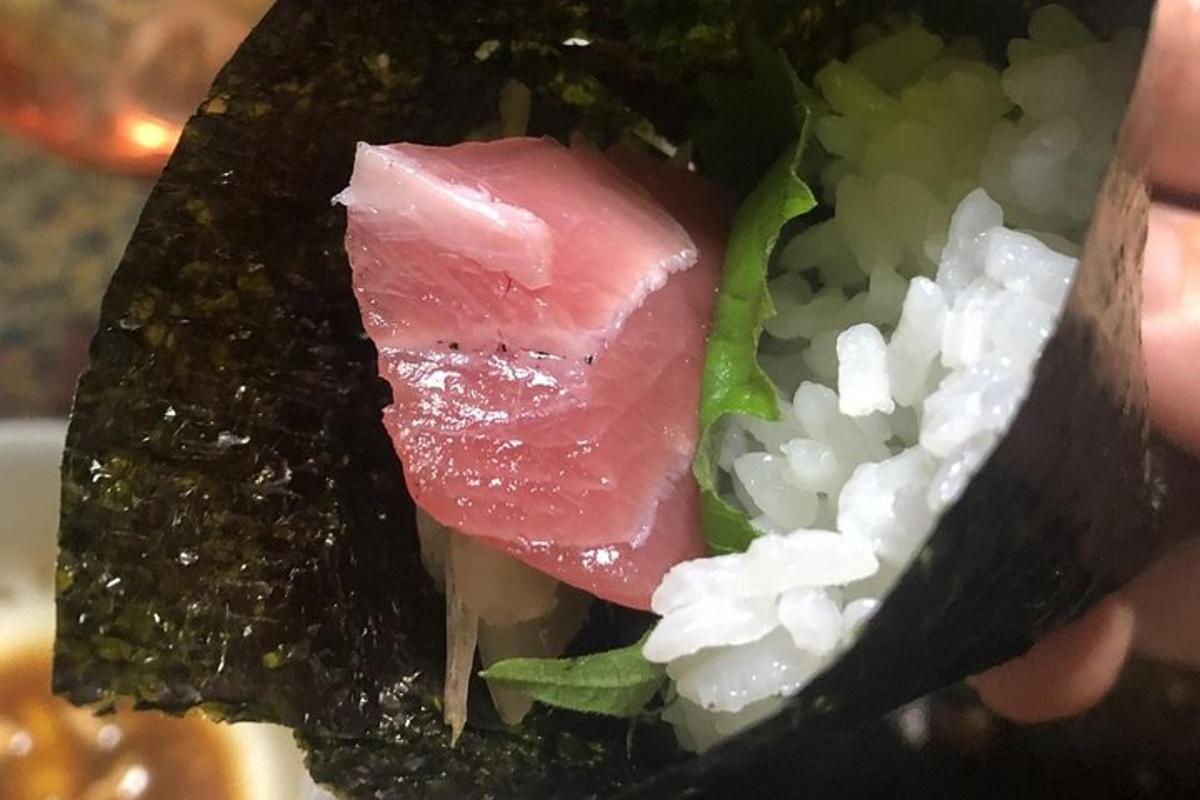 tangan memegang sandwic dengan daging dan sayur-sayuran