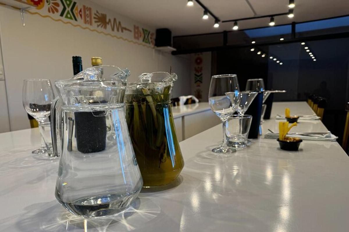Una mesa con copas de vino y un jarrón encima.