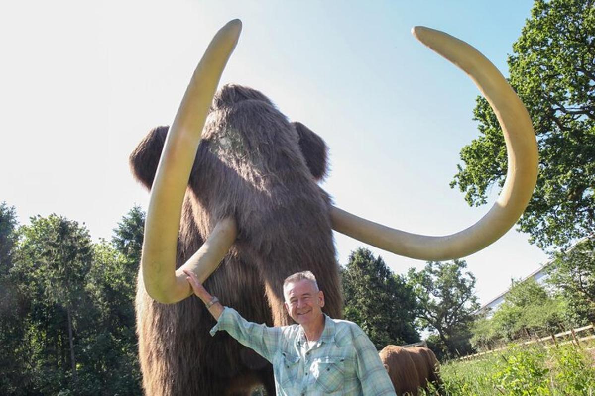 マンモスの像の前に立つ男性