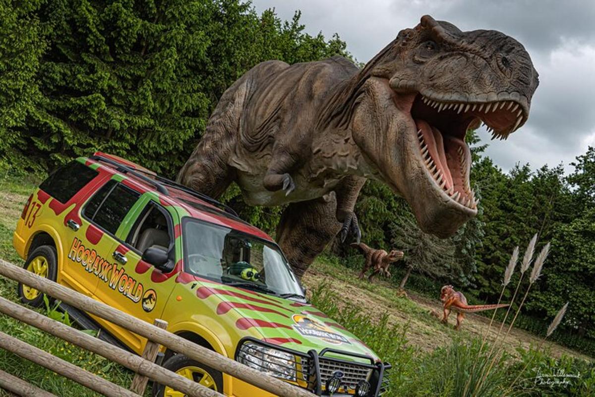 a dinosaur statue is next to a toy truck