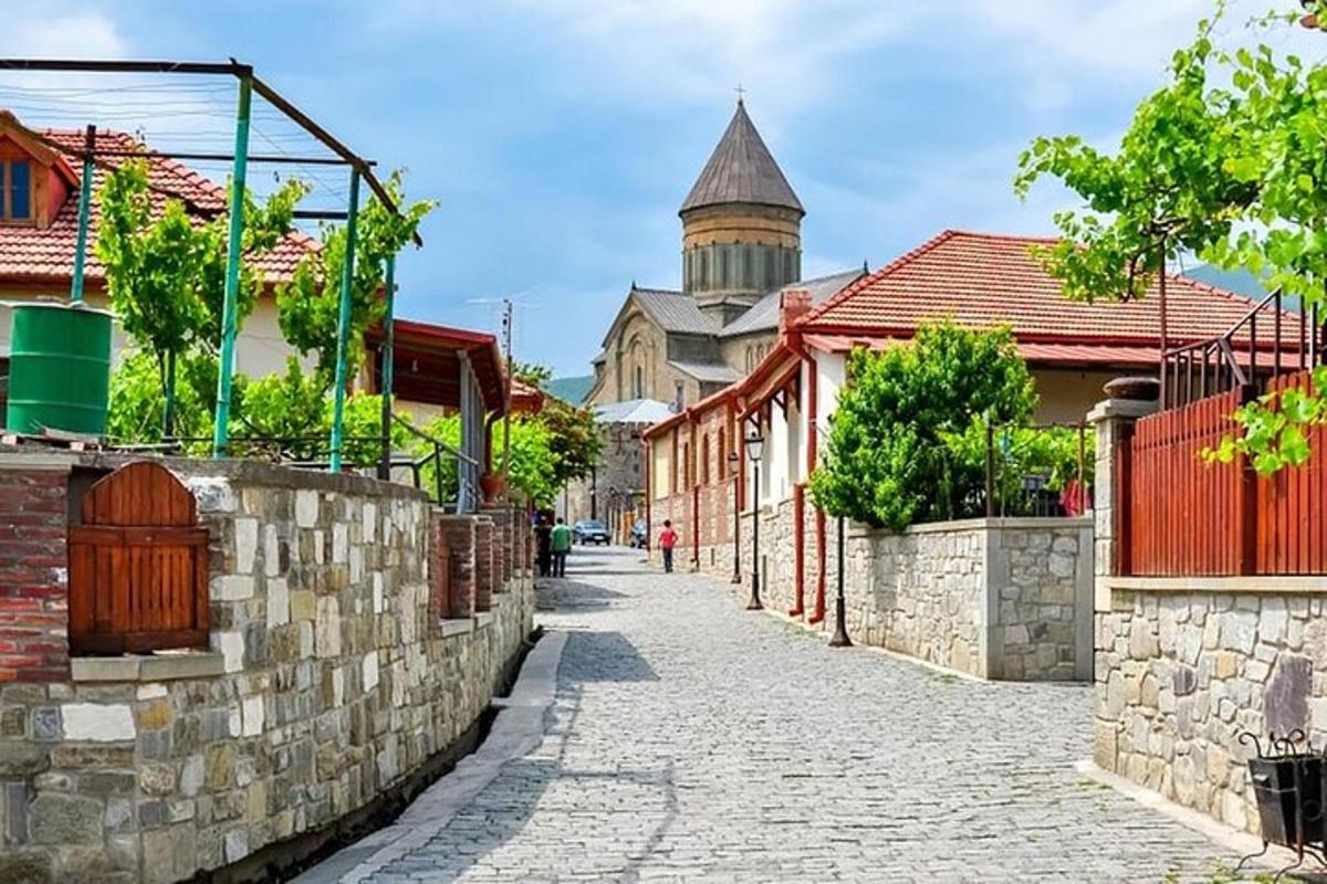 Una calle con un muro de piedra y un edificio.