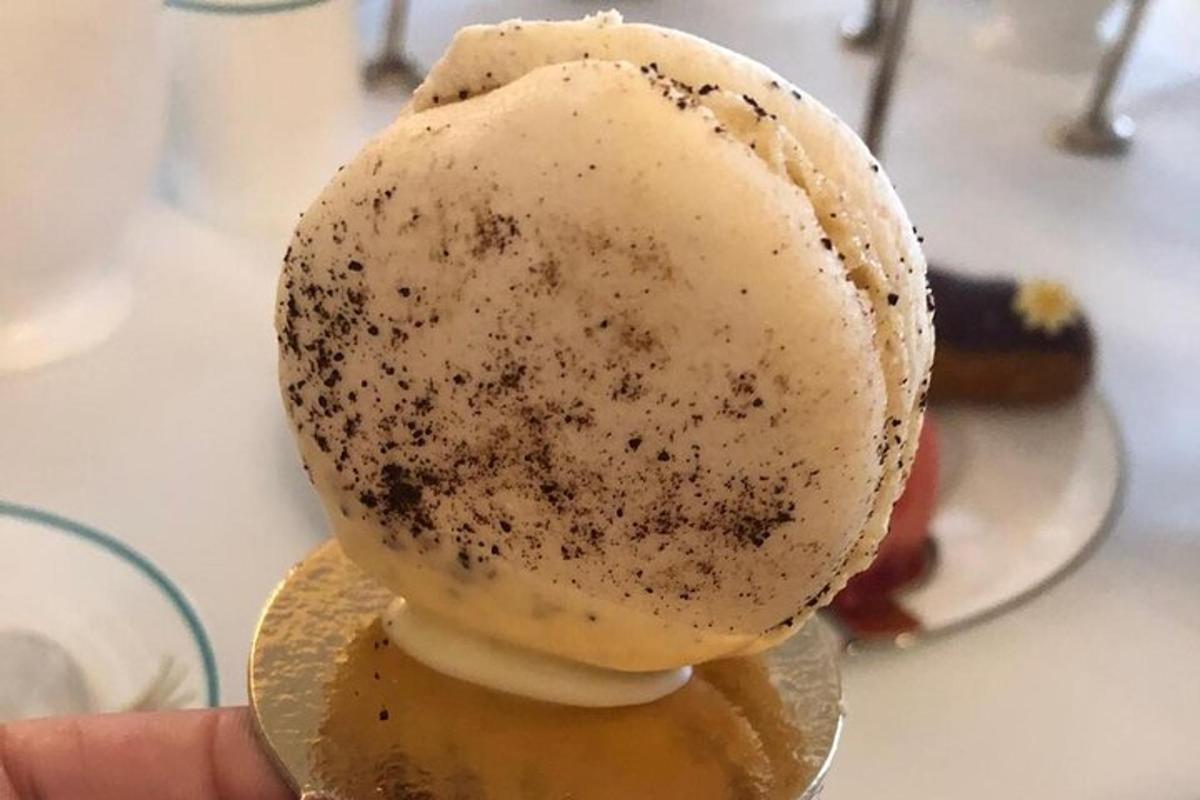 una persona che tiene in mano un cono gelato con del cioccolato sopra