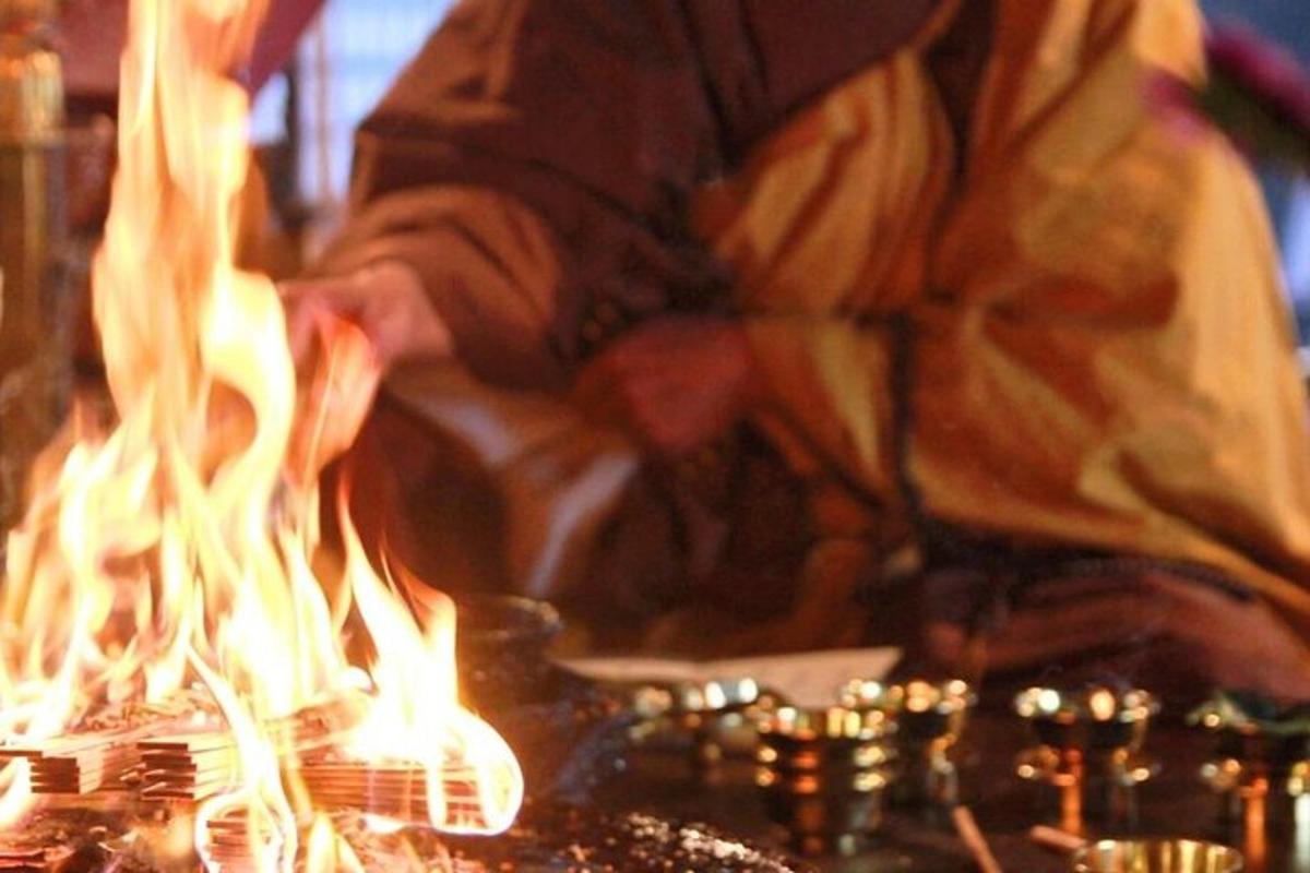 maður stendur við grill með eldi