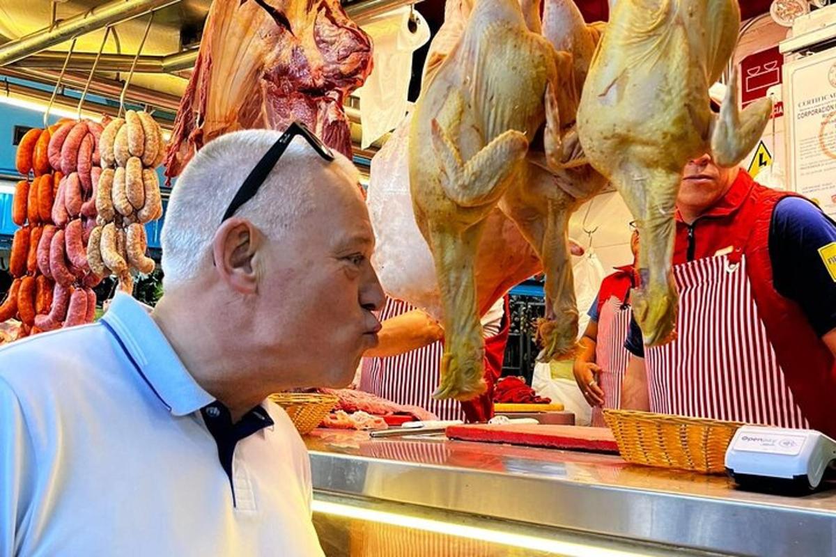 muž stojící v obchodě a prohlížející si maso