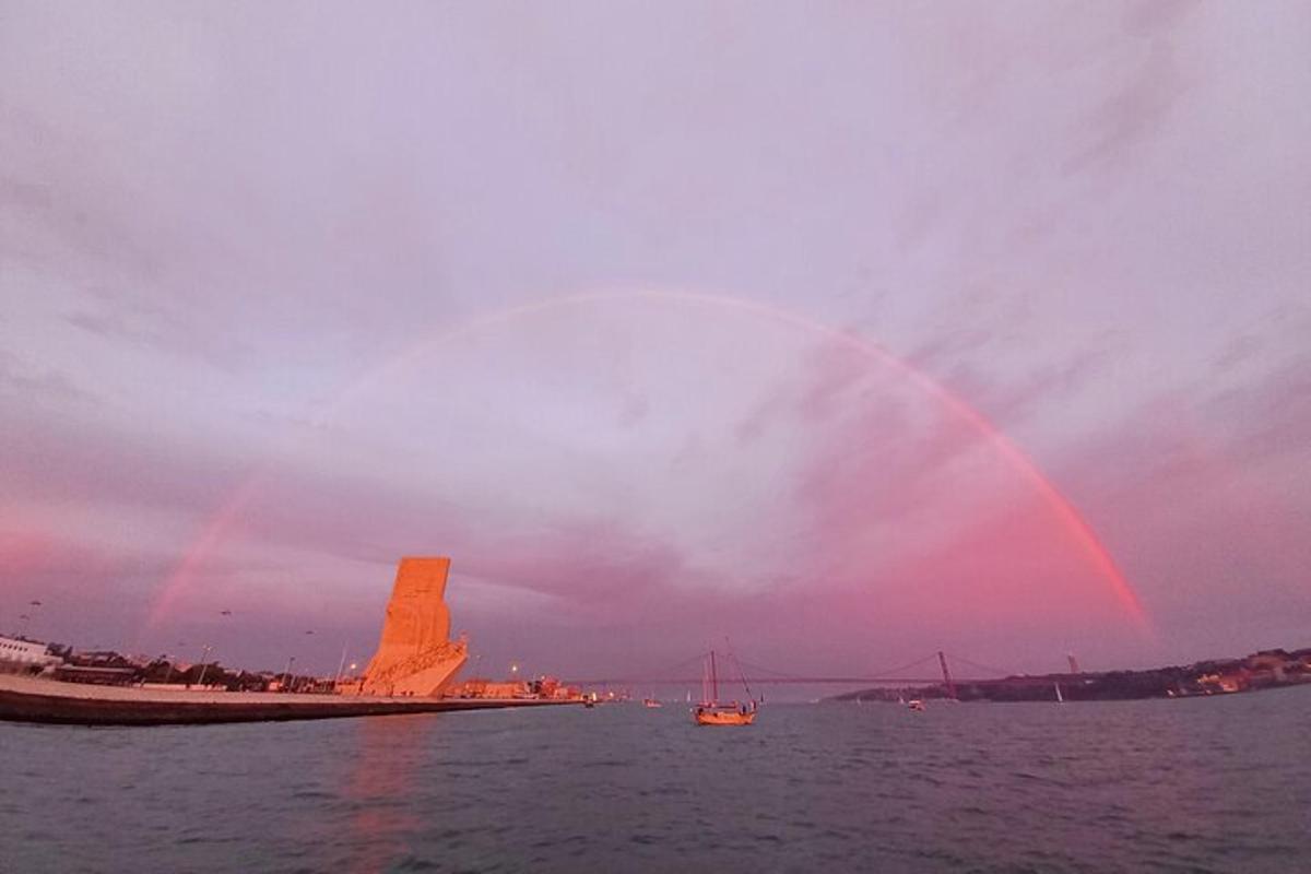 дуга на небу изнад воде са чамцем