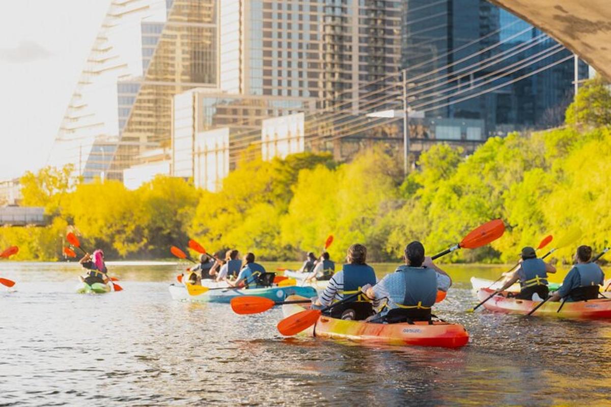 a group of people kayaking down a river in a city