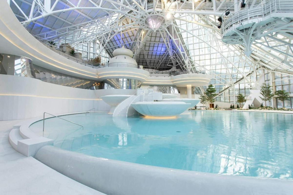 una piscina in un edificio con uno scivolo d'acqua