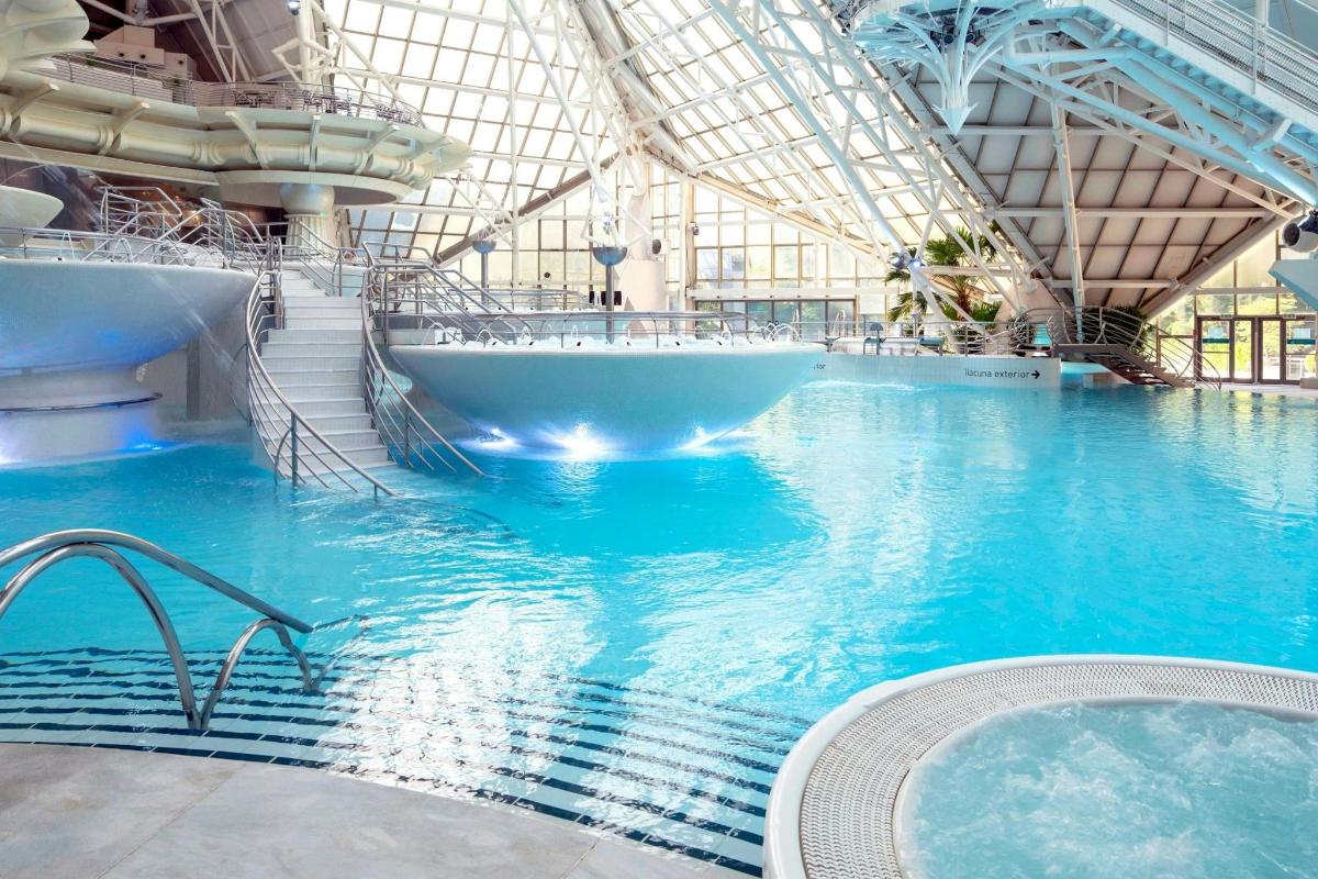 o piscină mare cu cadă într-o clădire