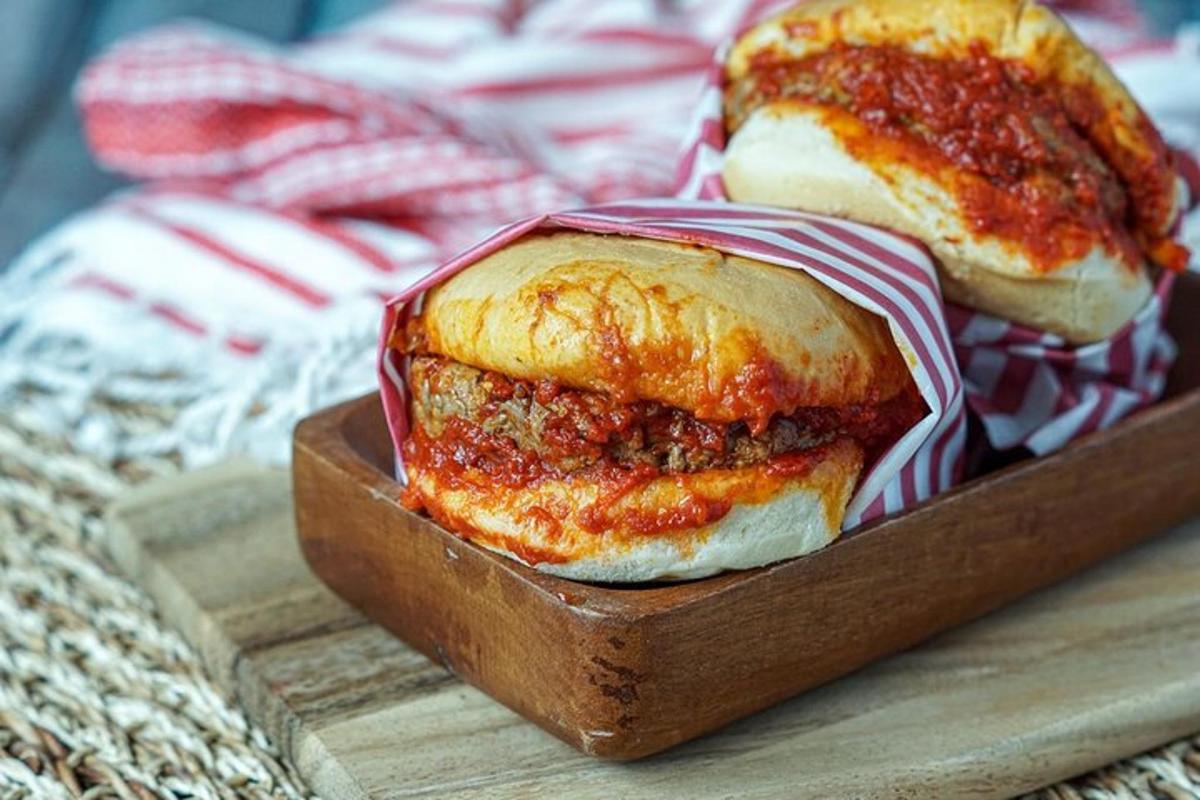 a meatball sandwich on a wooden cutting board