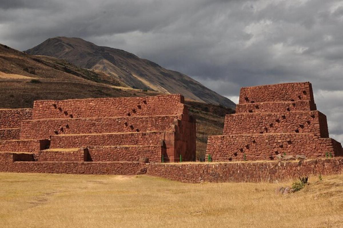 an ancient brick building with a mountain in the background