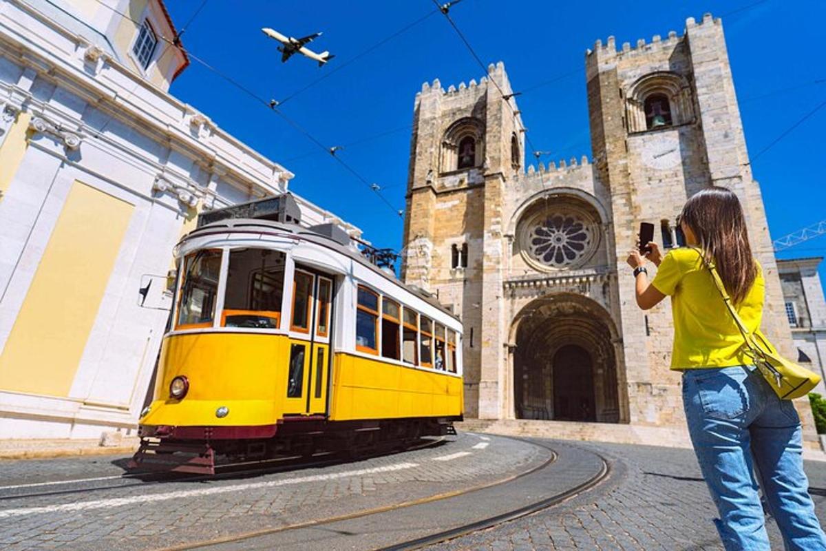 una donna che scatta una foto a un tram giallo davanti a una chiesa