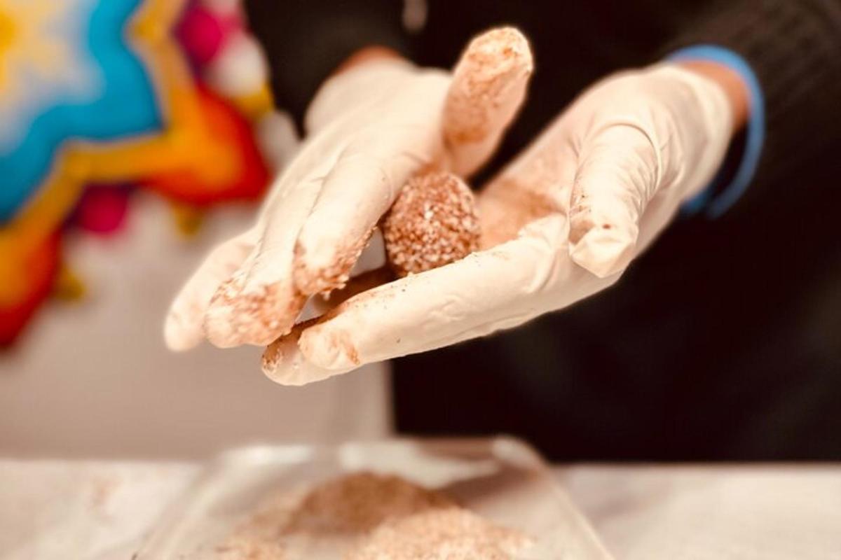 a person wearing white gloves holding a piece of food
