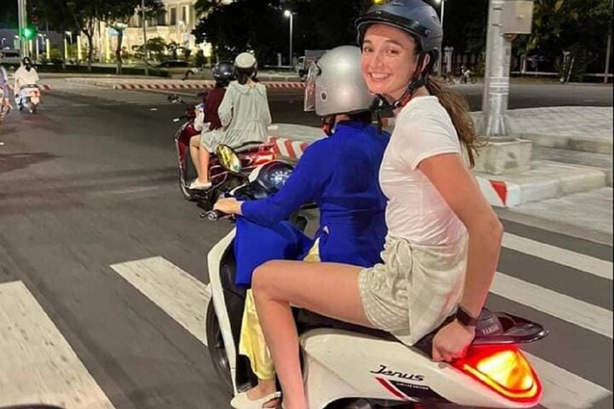 žena a muž jedoucí na skútru po ulici