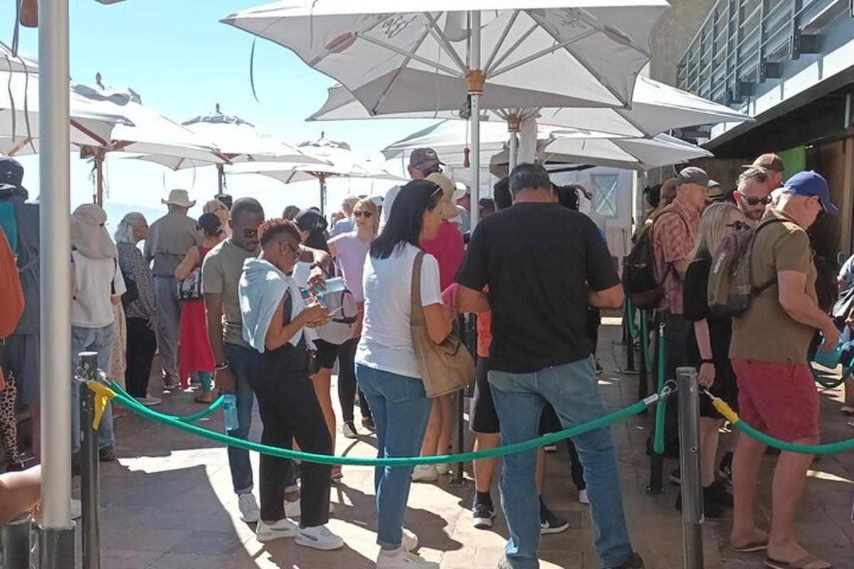 ένα πλήθος ανθρώπων που στέκονται κάτω από άσπρες ομπρέλες