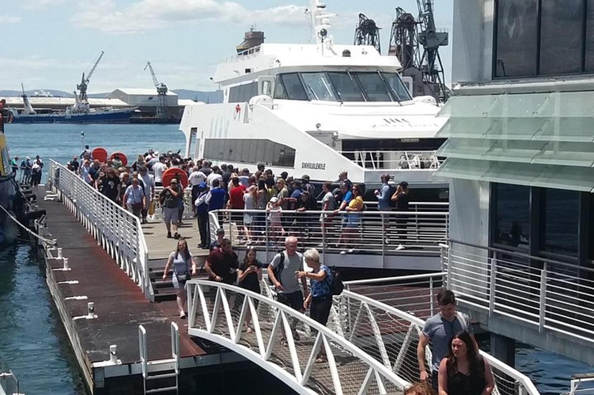 um grande grupo de pessoas entrando em um barco