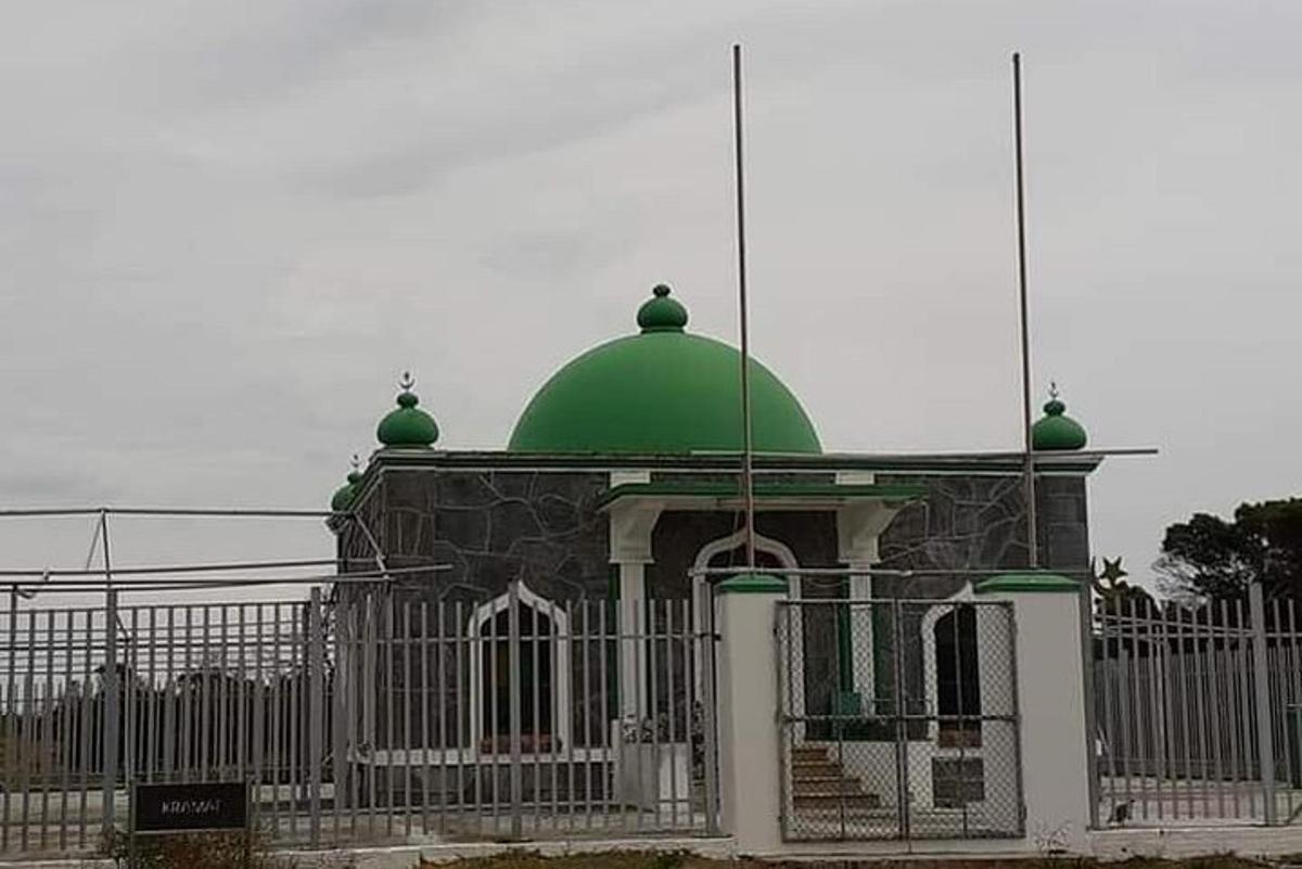 sebuah bangunan dengan kubah hijau di atas pagar
