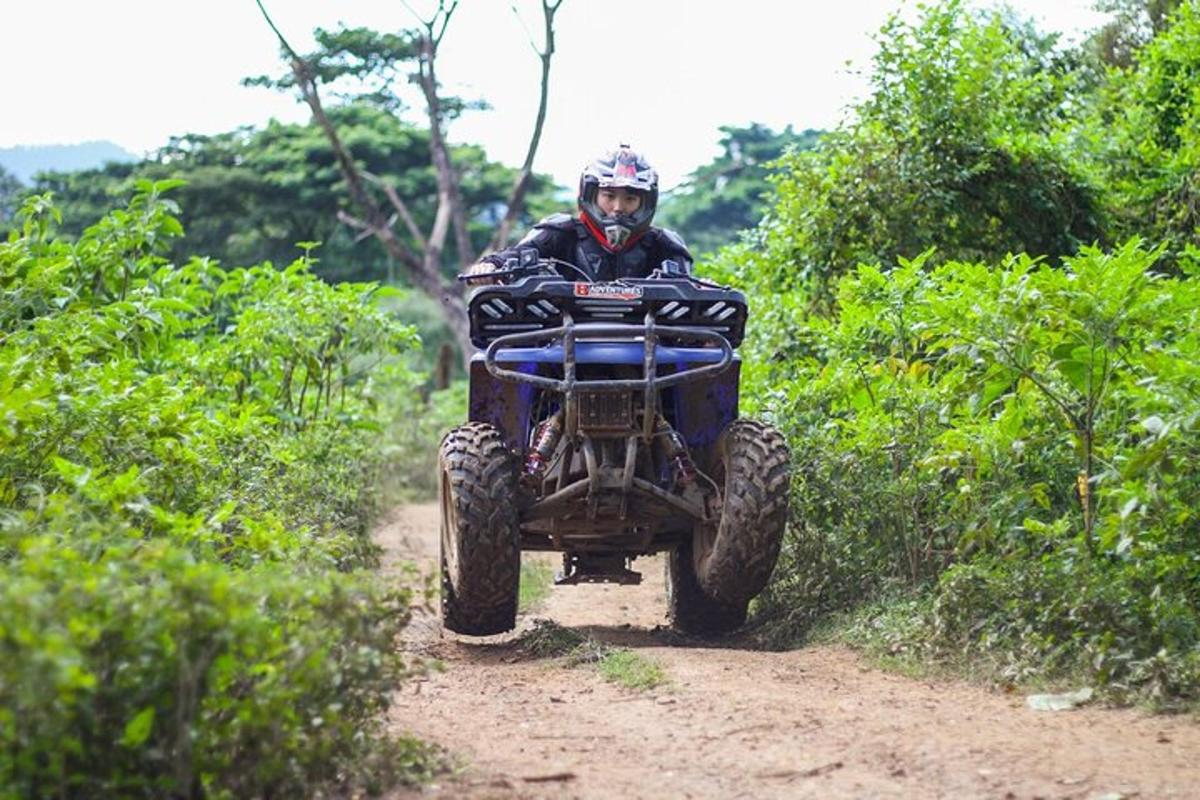 un uomo che guida un quad su una strada sterrata