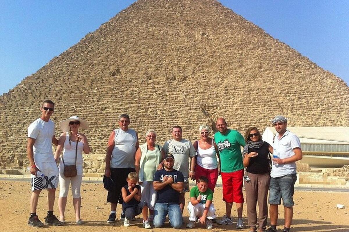 skupina lidí stojící před pyramidou