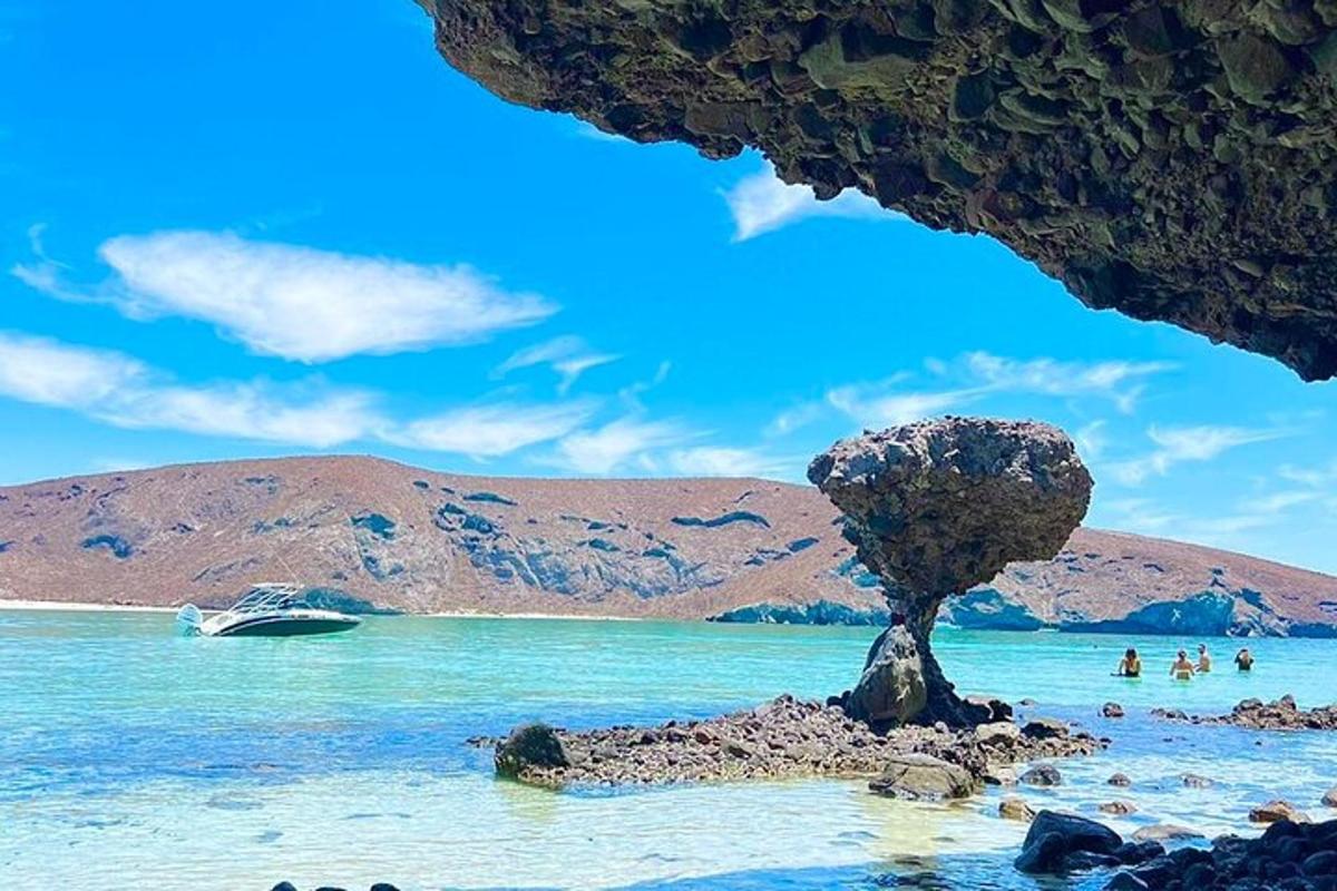 isang bato sa dalampasigan na may bangka sa tubig