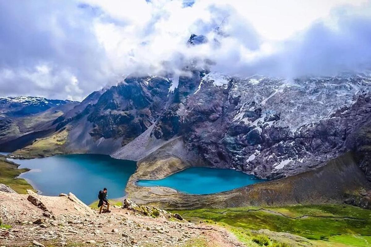 muž stojící na vrcholu hory s výhledem na jezero