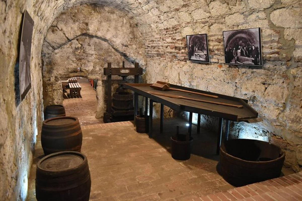 a wine tasting room with a table and barrels