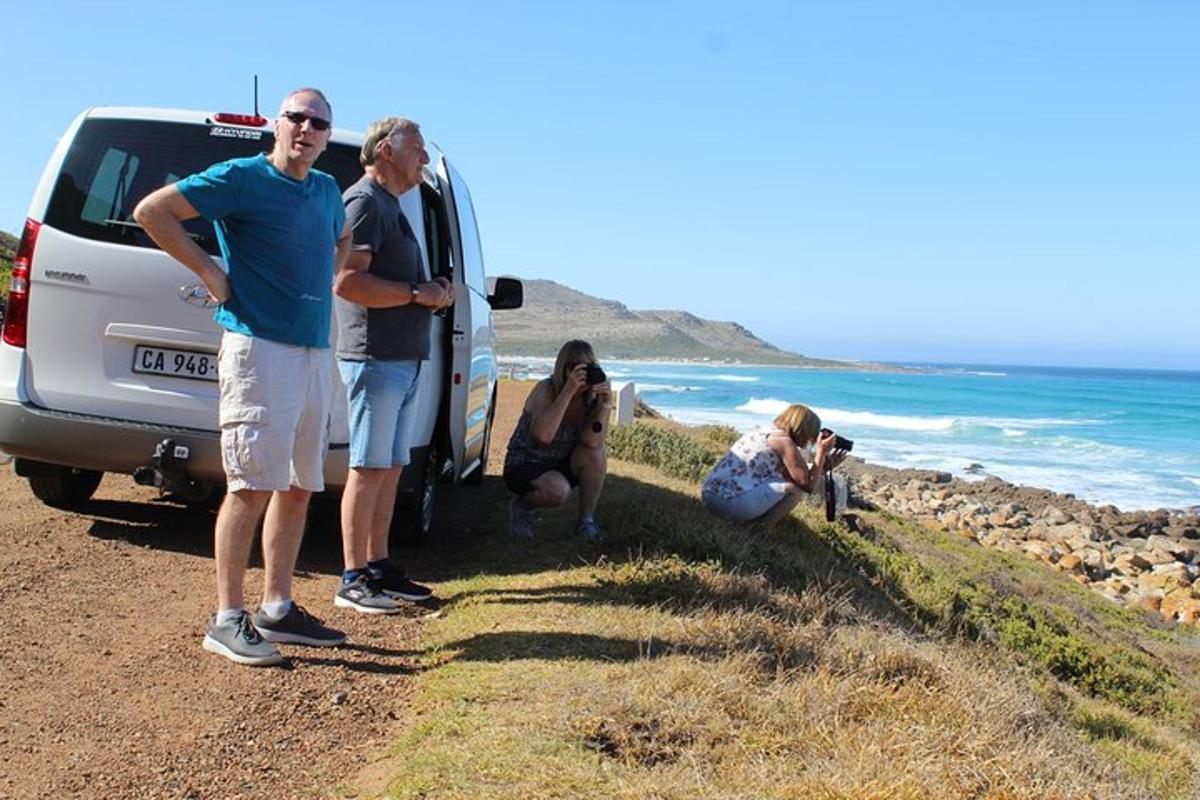 un gruppo di persone in piedi accanto a un camion sulla spiaggia