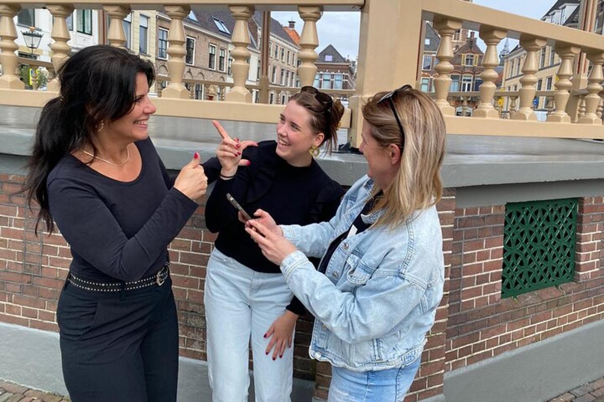 tři ženy stojící vedle sebe a dívající se na mobilní telefon