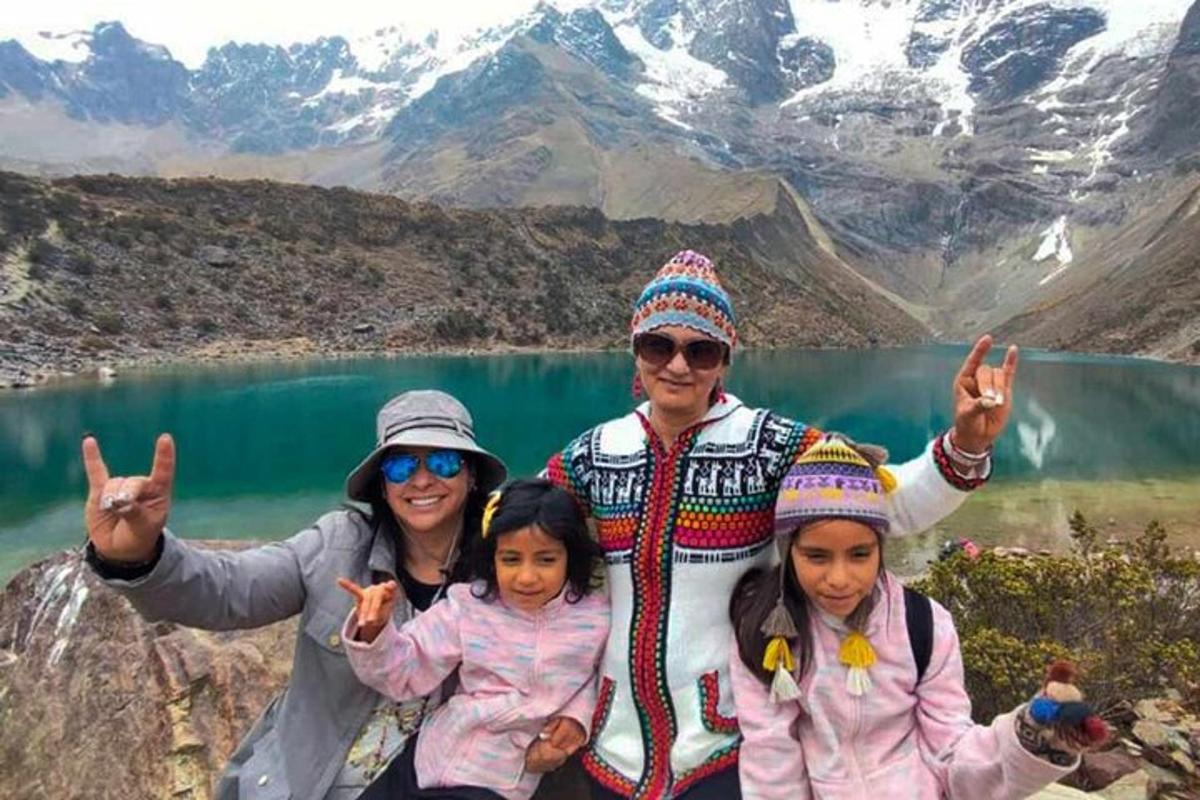 Un grupo de personas posando frente a una montaña.